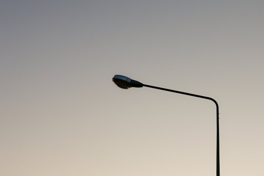 Silhouette light post during sun rise