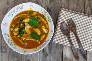 Spicy fish curry in bowl with fork and spoon