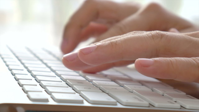 Woman's hands typing on modern computer keyboard. Freelancer use the internet to work from home.  