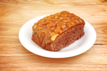 homemade toffee cake and white plate on wood with vignette