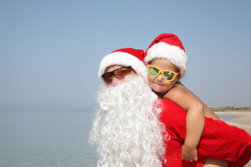 Santa with child on the beach