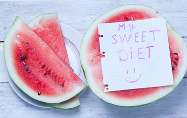  fresh ripe watermelon slices and a piece of paper with the words "my sweet diet" on the wooden table.top view