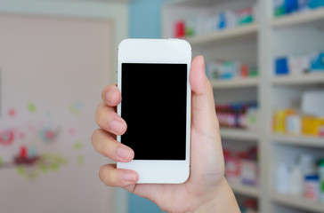 hand holding smart phone in drugstore