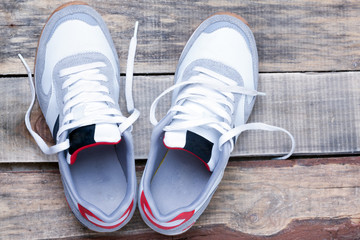 white running shoes on a wooden floor closeup view from above.