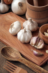 Garlic on cutting board , close-up on sacking. burlap background