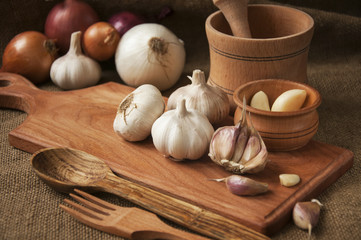 Garlic on cutting board , close-up on sacking. burlap background