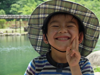 笑顔の少年　帽子　釣り堀　池