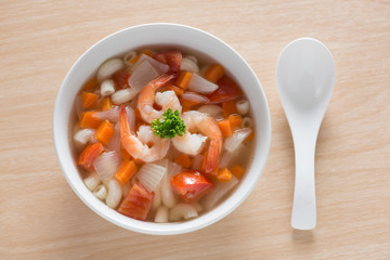 Macaroni with shrimp soup on white bowl.