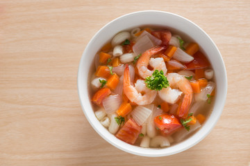 Macaroni with shrimp soup on white bowl. Top view.