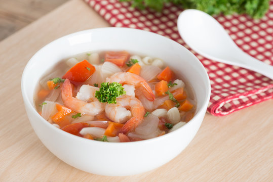 Macaroni with shrimp soup on white bowl.