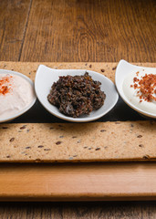 Three different sauces served on a wooden table 