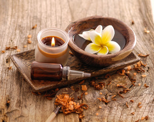 Fototapeta na wymiar frangipani and, dry flower petals ,candle on old wood