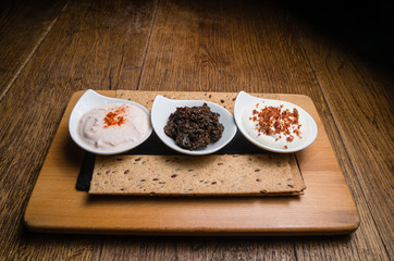 Three different sauces served on a wooden table 