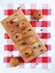 Freshly baked muffins sprinkles with sugar and black currant ber