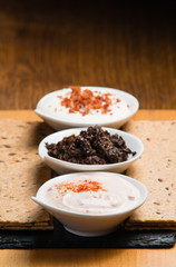 Three different sauces served on a wooden table 