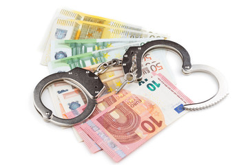 Handschellen auf dem Hintergrund von Banknoten