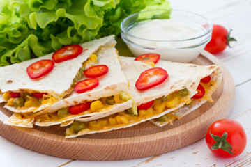 Quesadilla with sour cream, salad and tomatoes