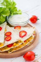Quesadilla with sour cream, salad and tomatoes
