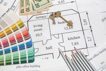 Closeup plan home with a palette of colors, pencils, keys and dollar
