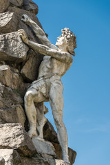 statue of a man climbing a rock - useful for concepts