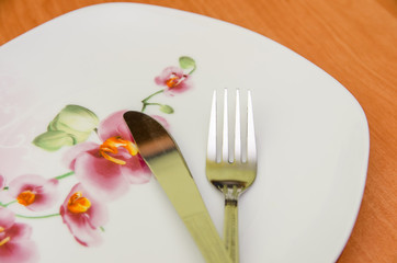 Empty plate with fork and knife on wood table