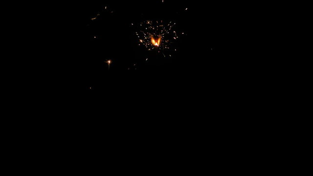 Centrally positioned firework sparkler burning isolated from start to end. Gun powder sparks shot against deep dark background