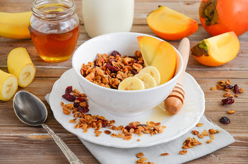 Homemade granola with nuts and dried cranberries on the rustic wooden table