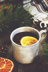 Winter drink with lemon and cranberries and cozy checked blanket