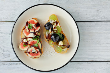 two toasts with fruits and cheese