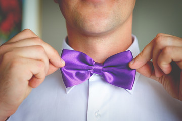 Man the groom in a wedding costume with butterfly. Hands, care, to correct, to adjust, fashion. Instagram colors toning © kulniz