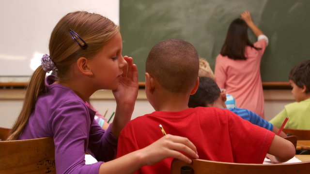 School children whispering during class