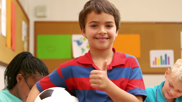 Boy with thumbs up holding a ball
