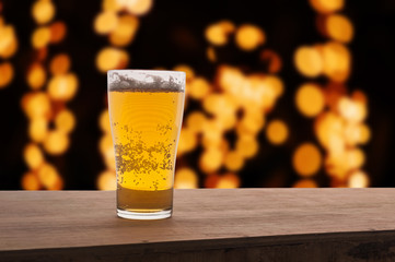 Glass of beer on light bokeh