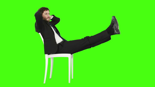 Businessman relaxing on a chair with legs up