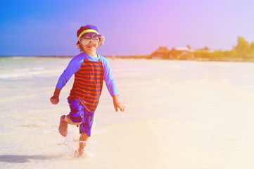 happy little boy running on tropical beach