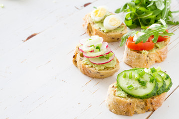 Summer sandwich and ingredients on white wood background
