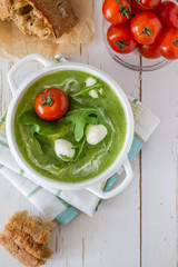Arugula and tomatoes puree soup in white bowl