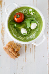 Arugula and tomatoes puree soup in white bowl