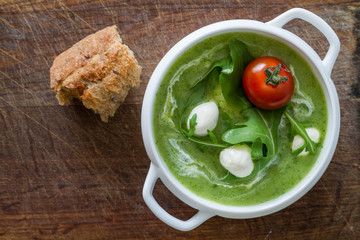 Arugula and tomatoes puree soup in white bowl