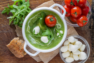 Arugula and tomatoes puree soup in white bowl