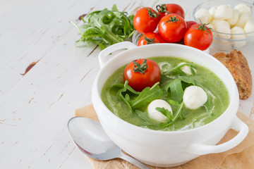 Arugula and tomatoes puree soup in white bowl