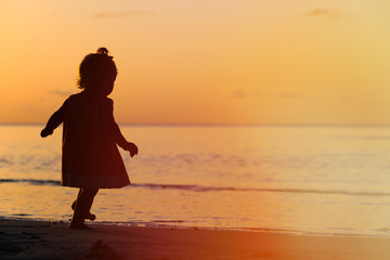 Fototapeta premium silhouette of little girl walking at sunset