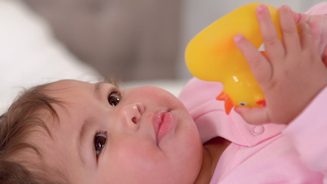 Cute baby girl playing with rubber ducky