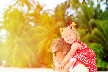 Happy father and cute little daughter at beach