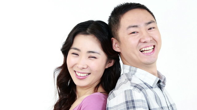 Smiling couple showing their thumbs at the camera