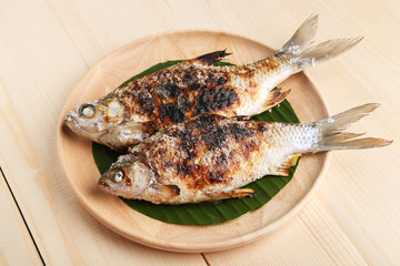 grilled fish on wooden plate