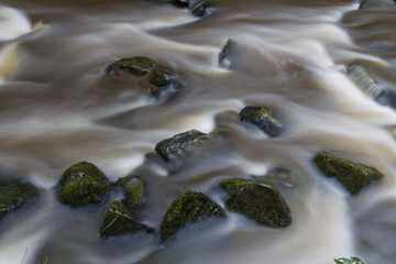 Water flowing over stones. near base of waterfall winter.