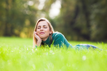 Happy woman relaxing and enjoying nature in park