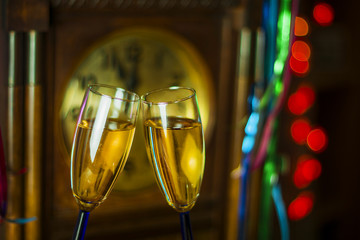 Glasses of champagne against the clock, streamers and lights © GieZetStudio