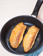 Fried fish fillet in a frying pan